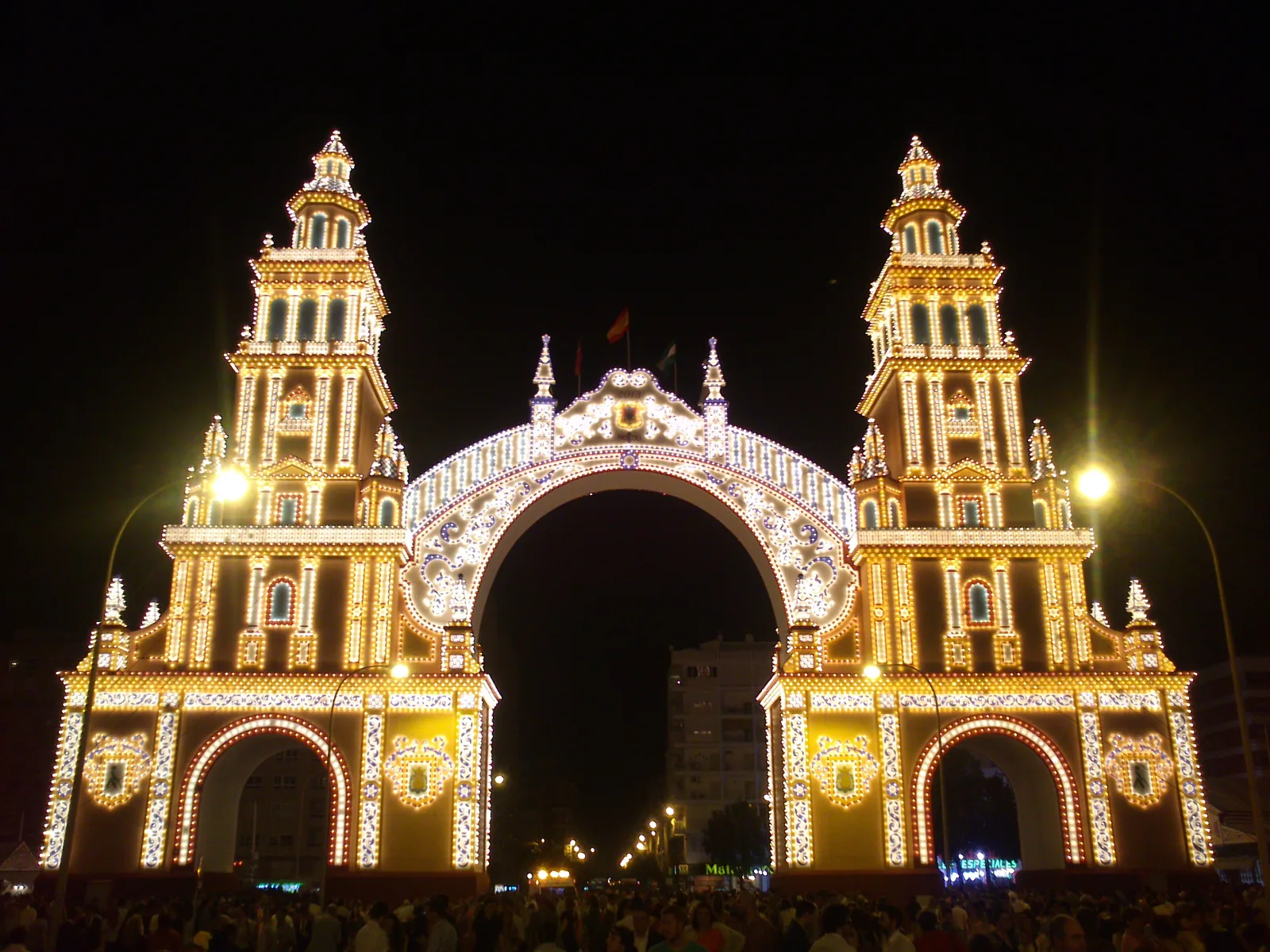 The illuminated portada gateway of the Feria de Abril fairground in Seville at night